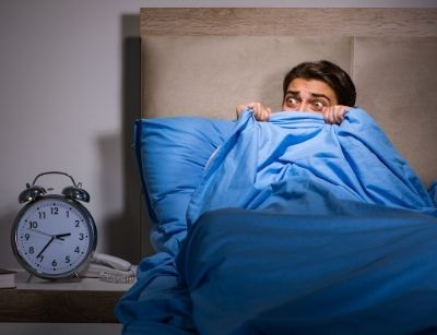 Person in bed afraid of clock
