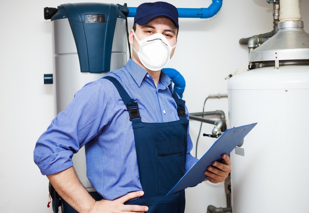 smiling technician servicing an hot water heater