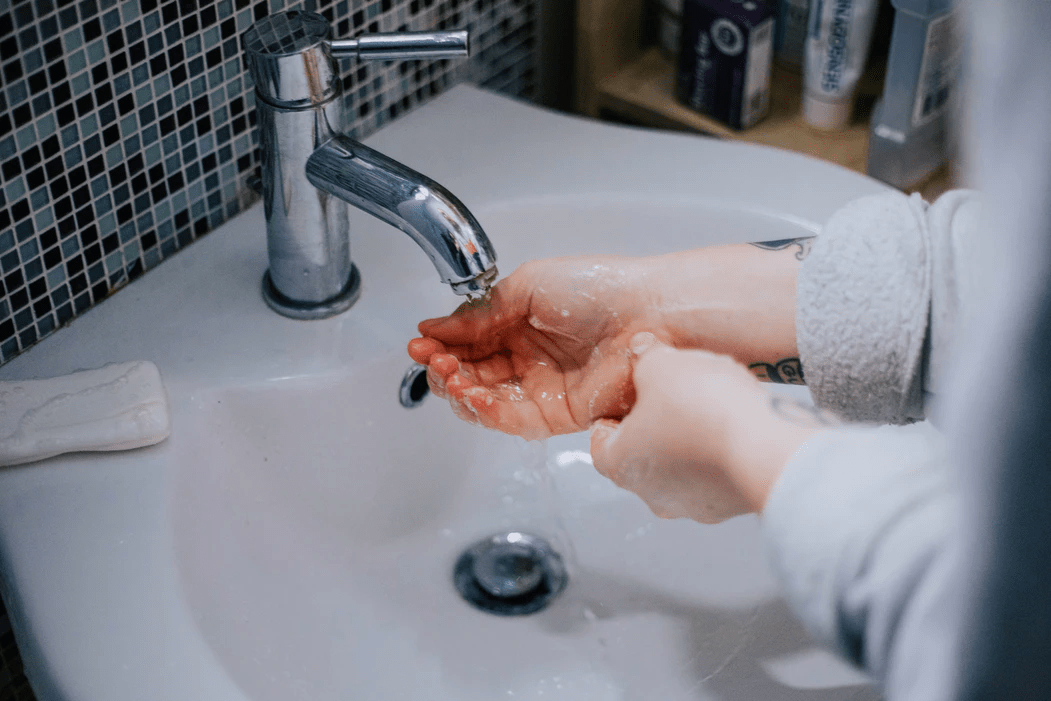 Woman washing hands in sink