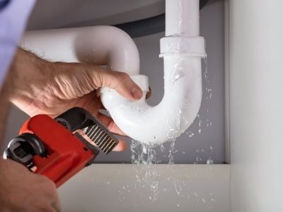 plumber fixing leaking sink pipes