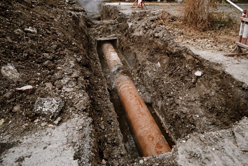 Rusty water pipe in the trench ground.