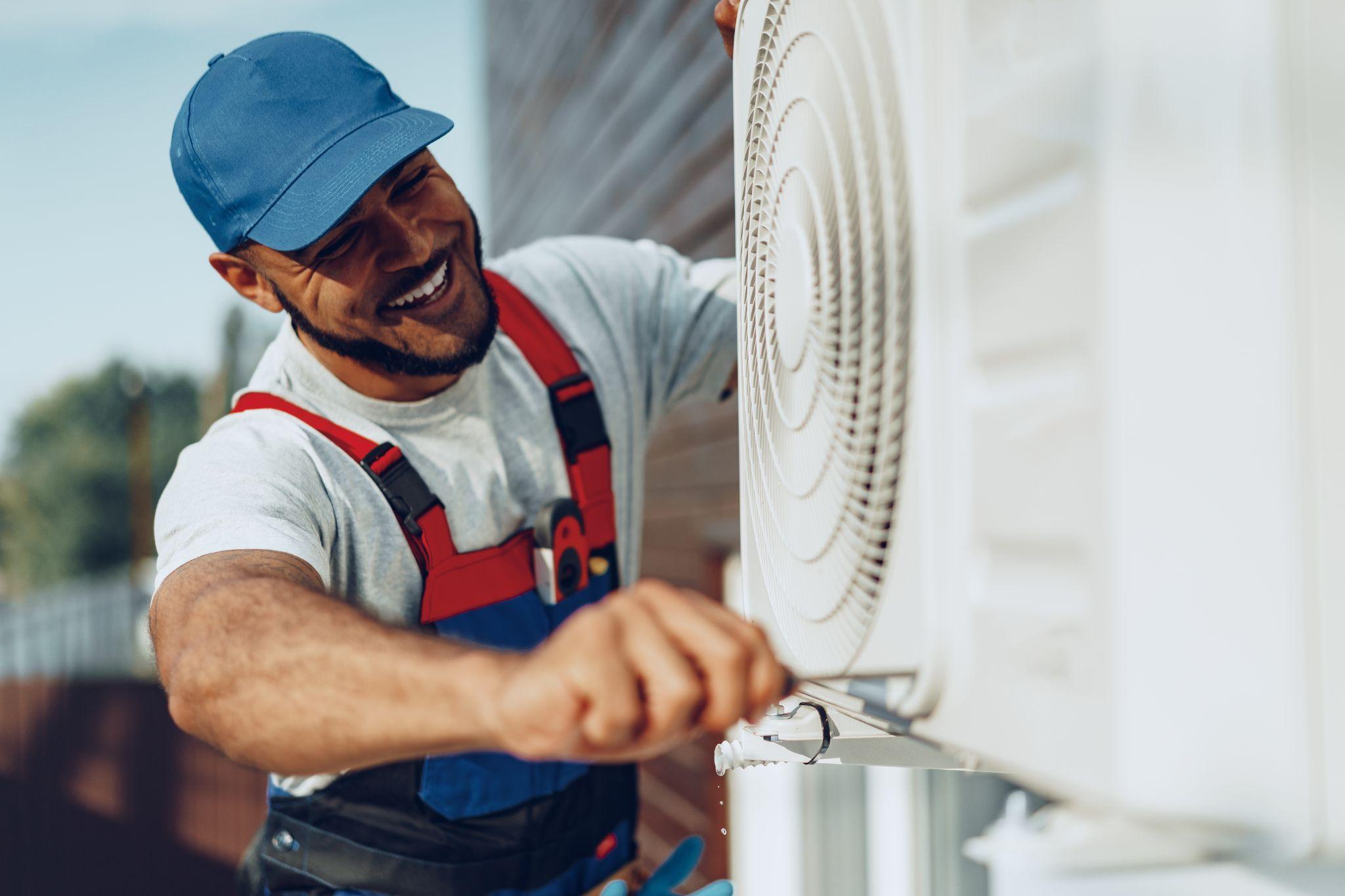 Young repairman checking an outside air conditioner unit