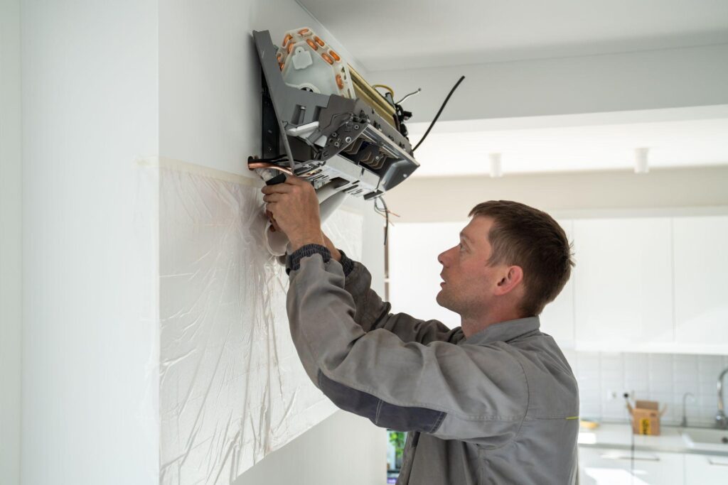 Man technician repairing apartment air conditioner